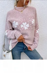 Detail of soft pink Christmas knit sweater featuring white snowflake patterns and texture