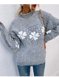 Close-up of semi-high collar blue knit sweater with large white snowflake clover pattern