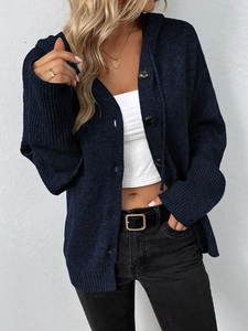 Detail der dunkelblauen Strickjacke mit Kapuze, schwarzen Knöpfen und Rippenstruktur