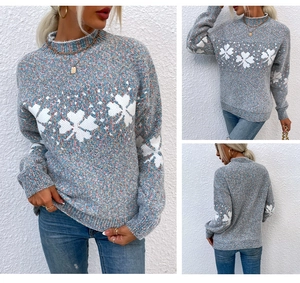 Detailed knit texture of blue grey Christmas sweater with large white snowflake patterns