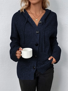 Detail der dunkelblauen Kapuzenstrickjacke mit großen schwarzen Knöpfen und Rippstruktur
