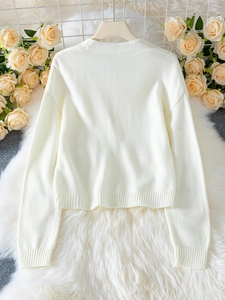 Vue arrière du cardigan en tricot blanc élégant avec motif fraise et finitions côtelées