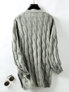 Close-up of gray cable knit sweater featuring side zipper detail and textured ribbing