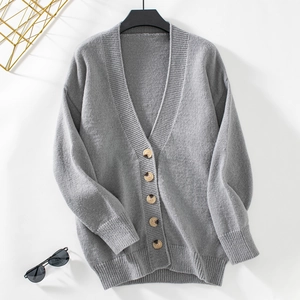 Gros plan d'un gilet en maille grise avec col en V et boutons à motif marbre foncé