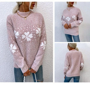 Detailed knit pattern on pink Christmas sweater with white snowflake motifs and high collar