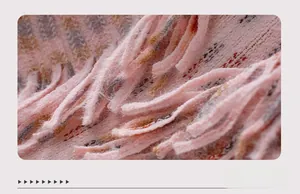 Detail of pink plaid knit fabric with soft fuzzy texture and fringe tassels edge