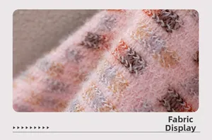 Close-up of pink and brown plaid knit fabric with a soft brushed texture and thick fringe