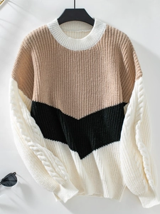Detail eines Colorblock-Zopfstrickpullovers mit V-Muster-Nähten und Rundhalsausschnitt