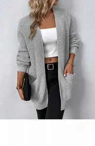Detail der grauen Waffelstrickjacke mit Vordertaschen und weicher Textur am Model