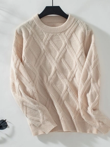Detailed view of diamond knit pattern on cream crew neck sweater with ribbed cuffs