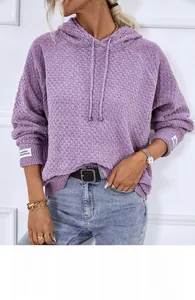 Detail of purple chenille knit hoodie featuring textured fabric and white woven sleeve label