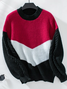 Detailansicht eines Grobstrickpullovers mit V-Farblock-Design und Zopfstrick-Ärmeln