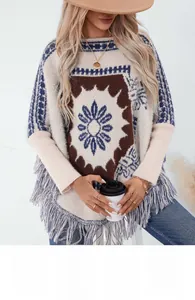 Detail of bohemian knit poncho featuring floral patterns and thick fringe tassels