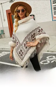 Detail of bohemian knit poncho with faux fur trim, snowflake patterns, and fringe hem