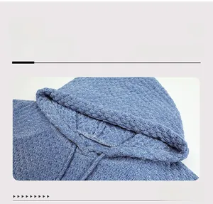 Detail of blue chenille knitted hoodie showing drawstring neckline and thick texture