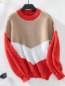 Detailaufnahme des Strickpullovers mit Farblock-Design und Zopfmuster-Struktur am Ärmel
