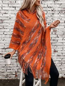 Detail of colorful striped knitted poncho with thick wool texture and long tassels