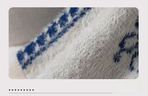 Close-up of bohemian knit cuffs featuring blue and white geometric patterns with fuzzy texture
