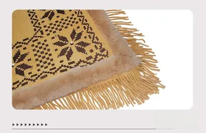 Detail of yellow knit shawl with snowflake pattern, faux fur collar, and beaded tassels