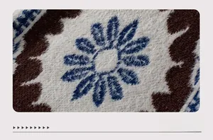 Detail of soft knit mohair fabric featuring blue daisy patterns on dark brown wool
