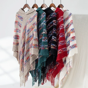Detail of colorful striped hooded knit ponchos with long tassels in multiple colors