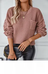 Detail of pink knitted sweater showing chest pocket and decorative popcorn stitch texture