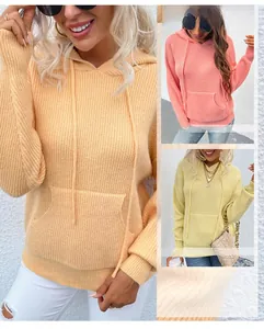 Détail de la maille côtelée du pull à capuche en rose poudré, jaune et couleur abricot