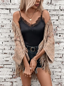 Women's plaid knit shawl poncho with fringe over lace satin top and denim shorts