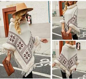 Detail of knit poncho featuring faux fur trim with geometric patterns and tassel hem