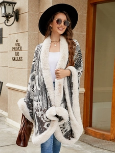 Detail of knit shawl with peacock pattern and thick faux fur trim on a female model