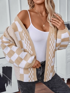 Detail of checkered knit cardigan showing soft beige plaid texture and lantern sleeves