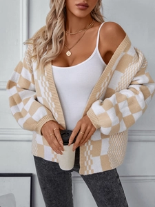 Detail of beige checkerboard knit cardigan with oversized lantern sleeves and golden necklaces