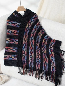 Detail of colorful geometric knit pattern and fringe hem on a hooded poncho shawl