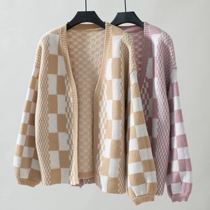 Detail of retro checkerboard knit cardigan with oversized lantern sleeves and ribbed cuffs