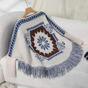 Detailed knit texture and tassels of a bohemian ethnic style knit poncho sweater
