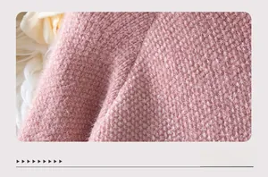 Dettaglio della morbida texture in finta pelliccia rosa di un maglione con cappuccio invernale