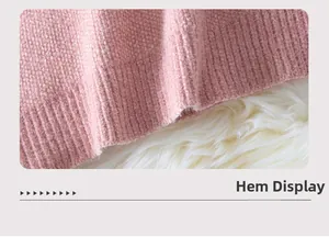 Dettaglio dell'orlo della felpa rosa con texture a coste su morbido tessuto a maglia