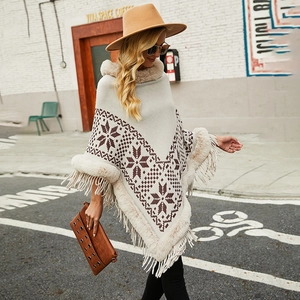 Women's bohemian knit poncho with snowflake patterns, faux fur collar and tassel hem