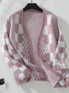 Detail view of pink and white checkered knit cardigan with rich woven texture and V-neck