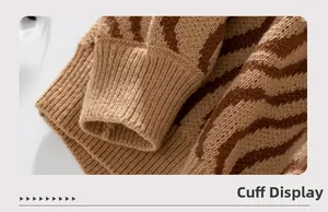 Detail of ribbed cuff and brown wave jacquard pattern on soft knit sweater