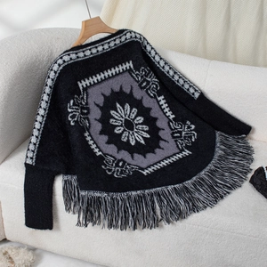 Detail of bohemian knit shawl featuring ethnic jacquard floral patterns and long fringe trim