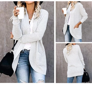 Detail of grey chunky knit cardigan with curved hem and functional patch pockets