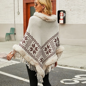 Women's knit poncho with faux fur collar, snowflake jacquard, and fringe tassels