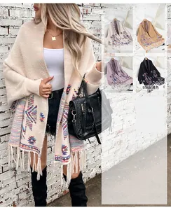 Detail view of Aztec geometric jacquard patterns and boho tassel fringe on women's cardigan