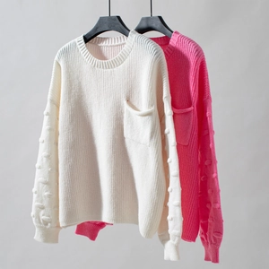 Detail of knit sweater showing textured polka dot sleeves and a minimalist front pocket