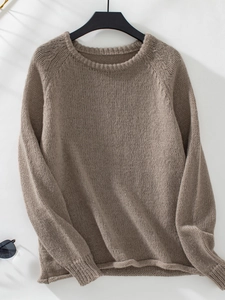 Detailed view of coffee brown knit sweater featuring ribbed crew neck and soft texture