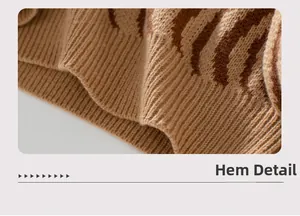 Detail view of the zebra pattern hem on a knit sweater with ribbed cuffs and soft texture