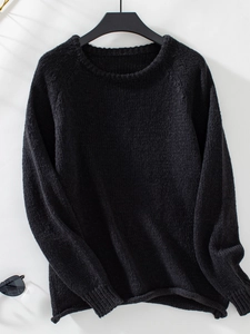 Detail of black knit sweater featuring a ribbed crew neck and premium knit texture