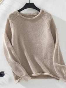 Detailed view of beige chunky knit sweater featuring crew neck and soft wool-like texture