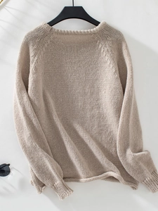 Detail of loose knit texture and ribbed neckline on beige oversized pullover sweater